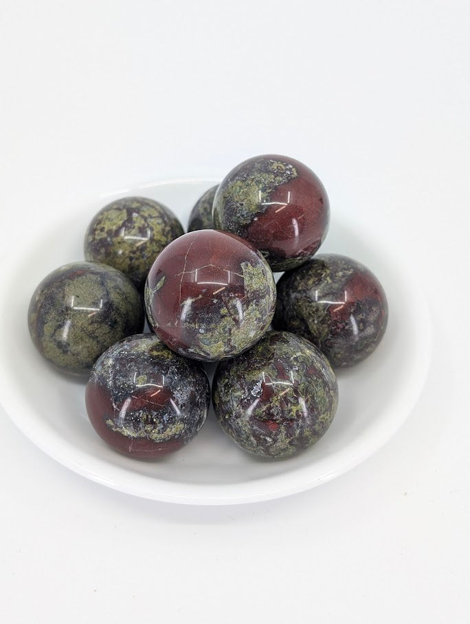 Dragon Blood Stone mini spheres in a bowl showing red and green patterning