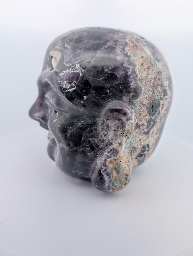 Side profile of Laughing Buddha carving showing chevron amethyst and natural matrix texture