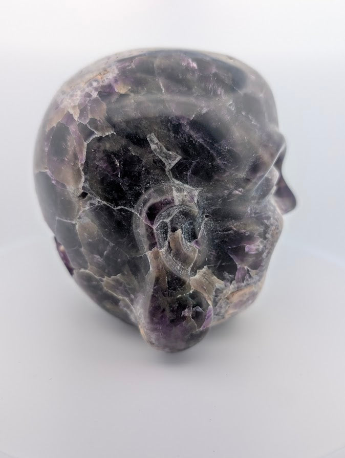 Side profile of Laughing Buddha carving showing chevron amethyst and natural matrix texture