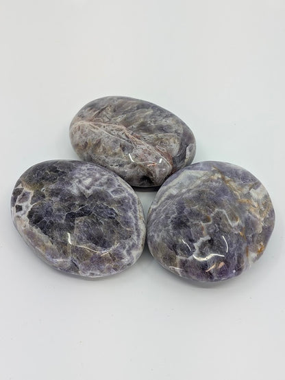 Group of Dream Amethyst Palm Stones showing polished chevron patterns and soft purple hues
