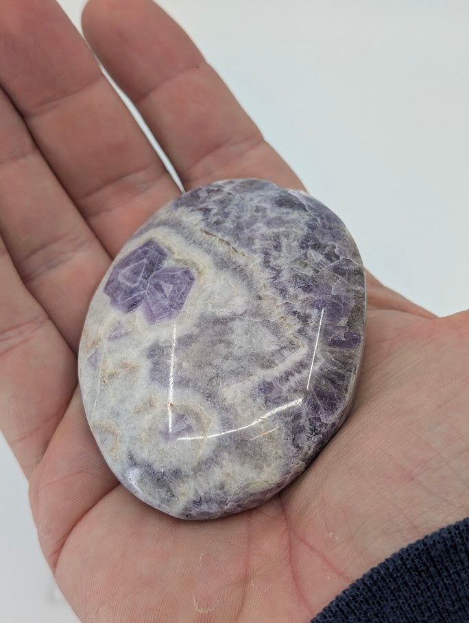 Dream Amethyst Palm Stone held in hand to show size and luster