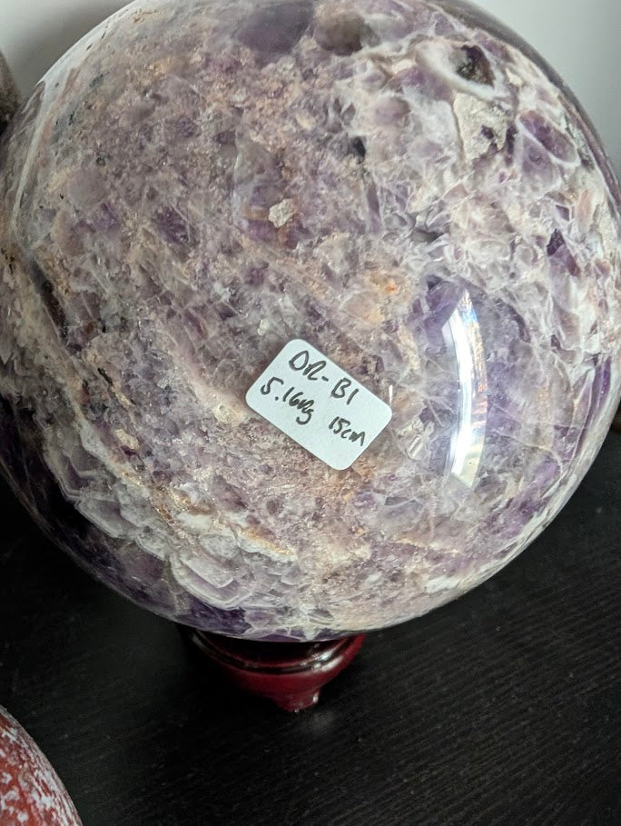 Bottom view of Dream Amethyst sphere showing symmetry of chevron bands and color contrast