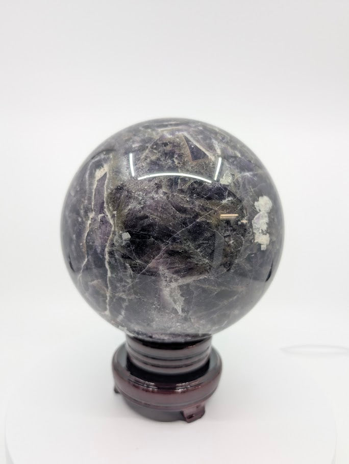Side view of Dream Amethyst sphere highlighting quartz layering and violet banding
