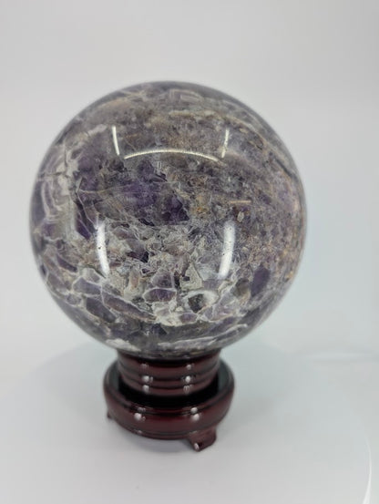 Close-up of Dream Amethyst sphere surface with natural texture and polish reflection