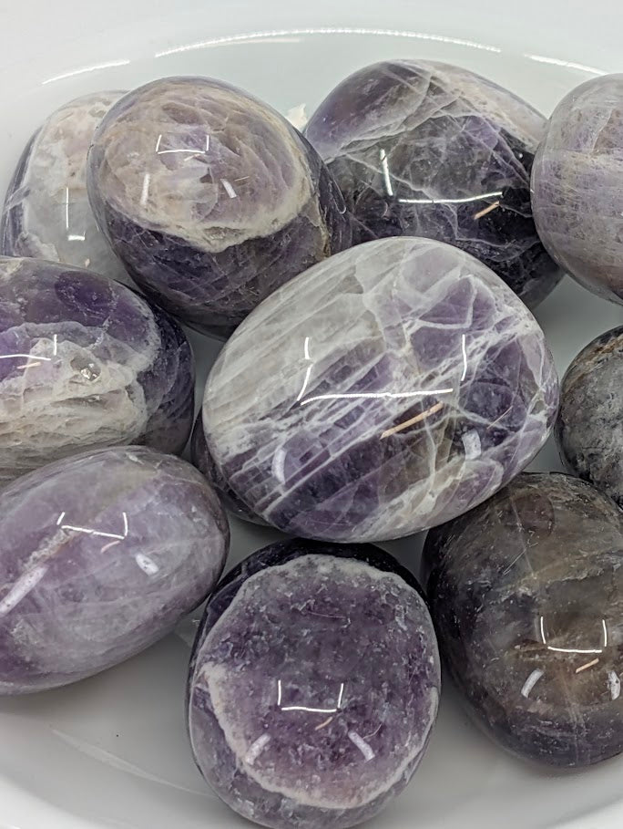 Close-up of Dream Amethyst tumbled stones showing purple and white quartz layering