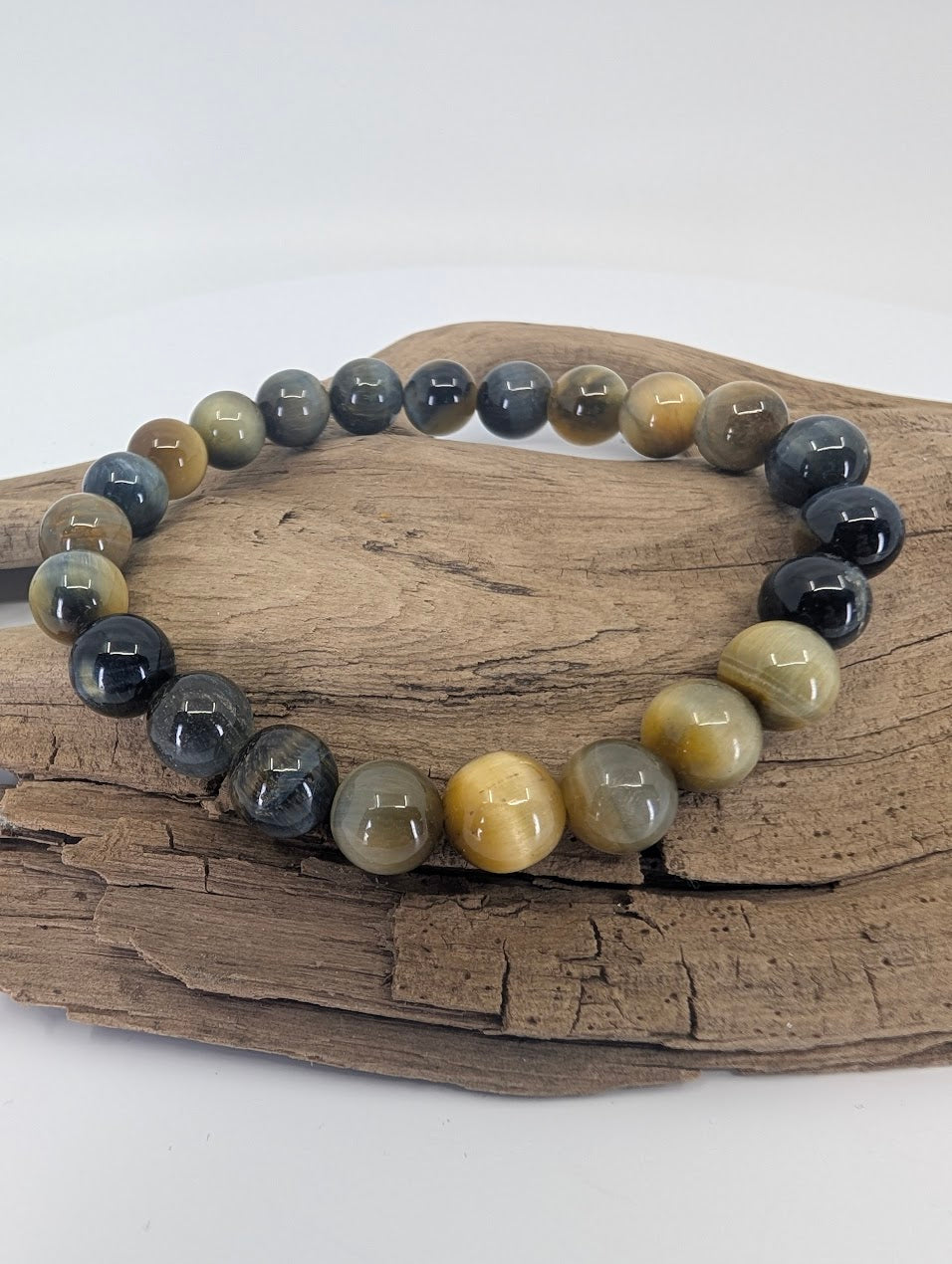 Dream Tiger’s Eye bracelet with 8mm beads displayed on driftwood