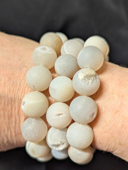 Lifestyle portrait of a stack of 14mm Druzy Agate bracelets on a wrist, demonstrating the matte aesthetic.