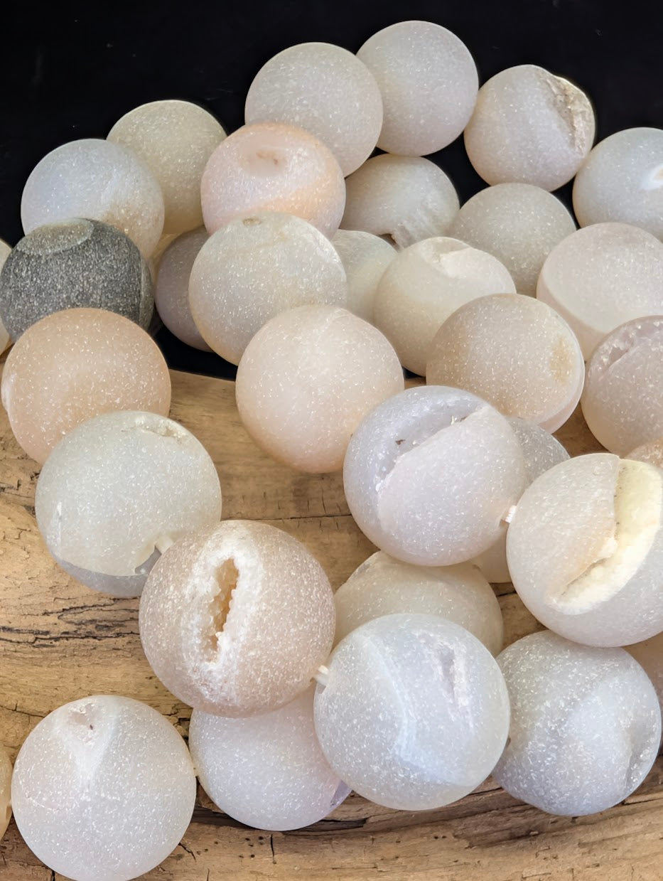 Macro detail of 14mm Agate beads highlighting the sparkling quartz crystals inside the natural vugs.