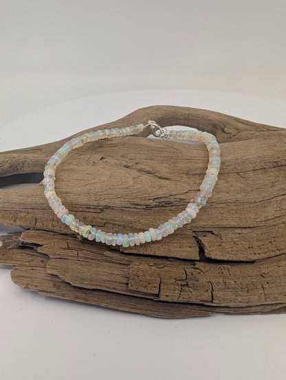 Ethiopian opal bracelet 3.6mm beads displayed on driftwood