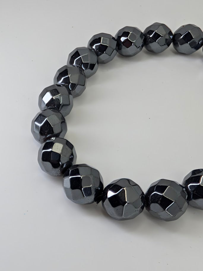 Angled photo highlighting the shine and geometric facets of hematite beads