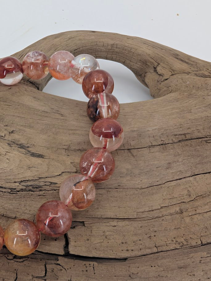 Close-up of Fire Quartz 8mm bracelet highlighting polished hematite inclusions