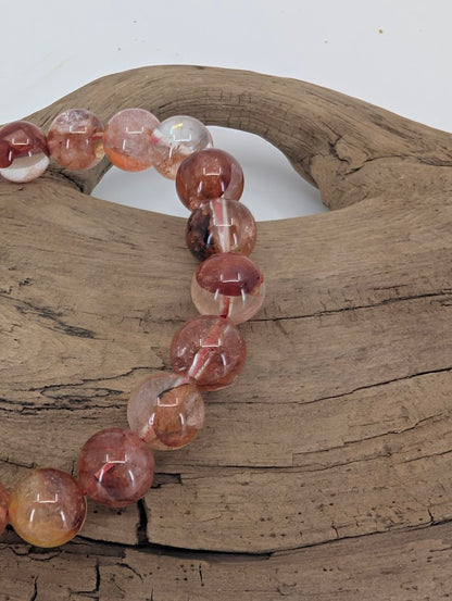 Close-up of Fire Quartz 8mm bracelet highlighting polished hematite inclusions