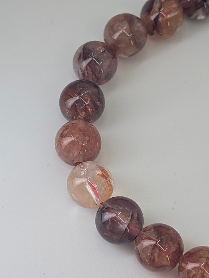 Fire Quartz bracelet glowing under light, revealing deep red and orange tones