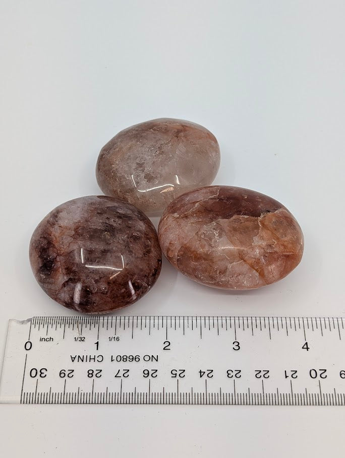 Fire Quartz Palm Stones beside ruler for scale reference