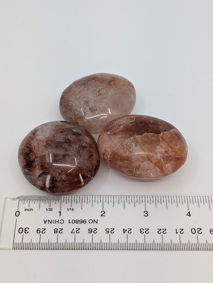Fire Quartz Palm Stones beside ruler for scale reference