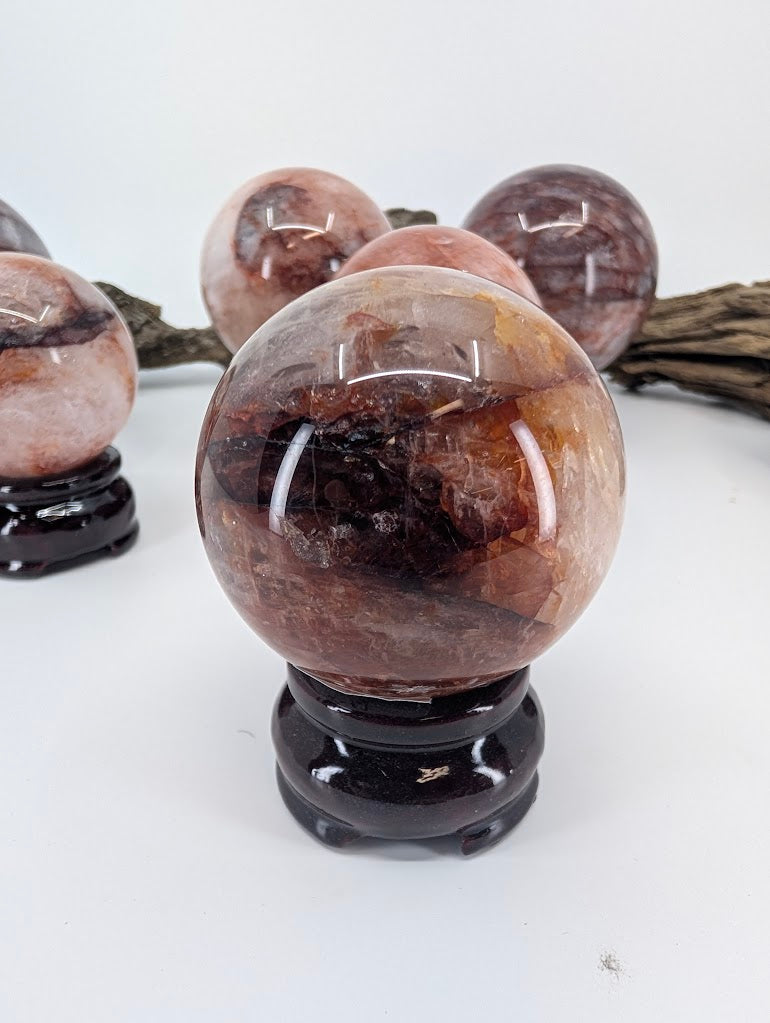 Detailed visual focus on the rich amber-yellow limonite and golden healer patches inside polished Fire Quartz sphere FQ-12 from Brazil.