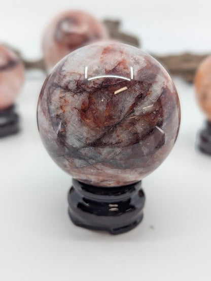 Isolated studio portrait orientation of Brazilian Hematoid Quartz sphere FQ-13, highlighting the fine geometric grid of reddish-brown inclusions.