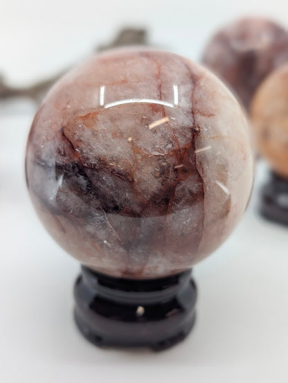 Polished profile view of natural Hematoid Quartz sphere FQ-14 from Brazil, highlighting the subtle iron staining and primary structural line.