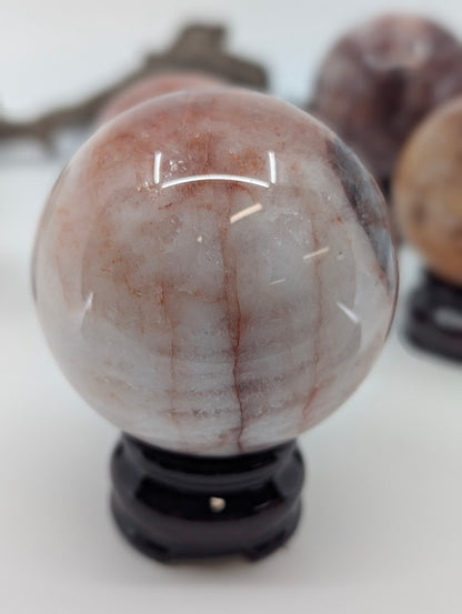 Polished profile view of natural Hematoid Quartz sphere FQ-14 from Brazil, highlighting the subtle iron staining and primary structural line.
