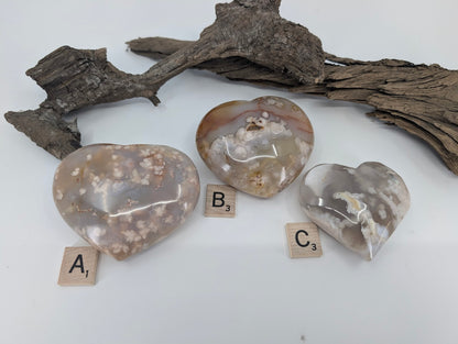 Back side of group of three Flower Agate hearts labeled A, B, and C showing blossom patterns.