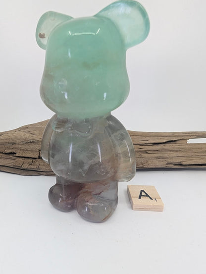 Rainbow Fluorite bear carving specimen A showing a mint-green head and purple-toned body.