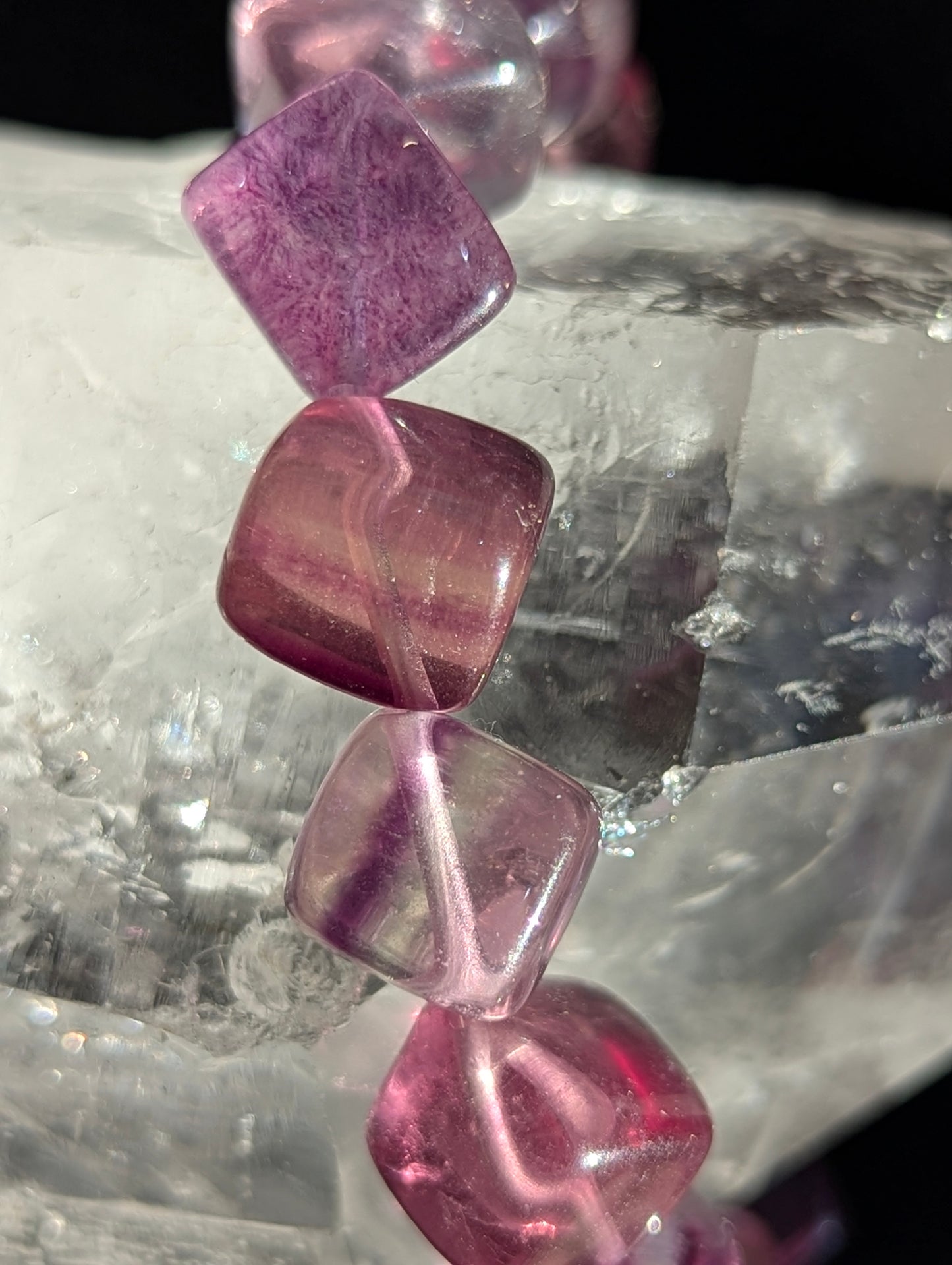 Macro close-up view of polished 10mm Banded Purple Fluorite cubes, highlighting the vitreous surface luster and natural cubic geometry.
