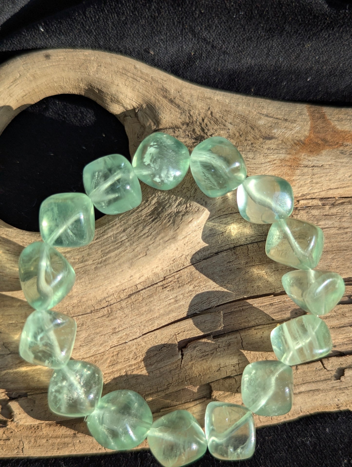 Alternate display angle of the 11.5mm Green Fluorite bracelet, showcasing the transparent to translucent matrices under balanced daylight.