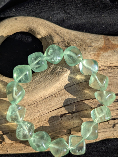 Alternate display angle of the 11.5mm Green Fluorite bracelet, showcasing the transparent to translucent matrices under balanced daylight.