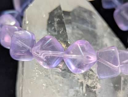 Macro close-up view of polished 10mm Lilac Purple Fluorite cubes, highlighting the fine structural colour boundaries within the calcium fluoride matrix.
