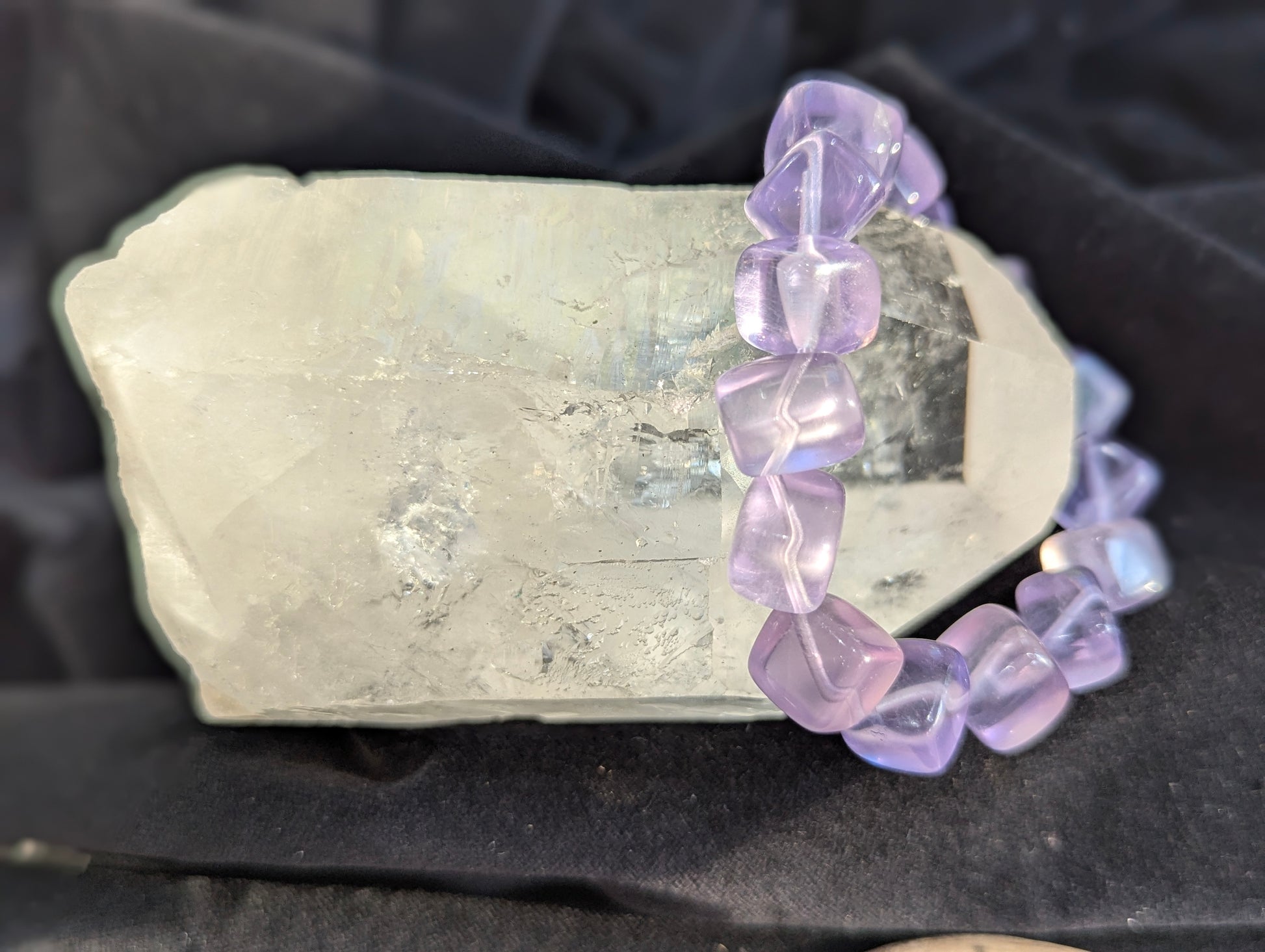 Premium 10mm Lilac Purple Fluorite beaded stretch bracelet displayed on a wrist to demonstrate its 17cm scale and continuous light refraction.