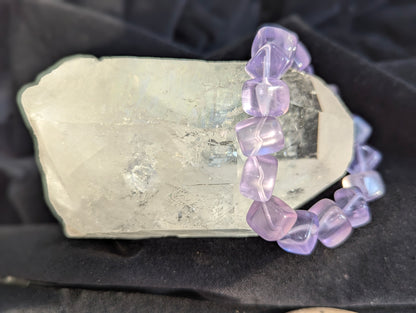 Premium 10mm Lilac Purple Fluorite beaded stretch bracelet displayed on a wrist to demonstrate its 17cm scale and continuous light refraction.