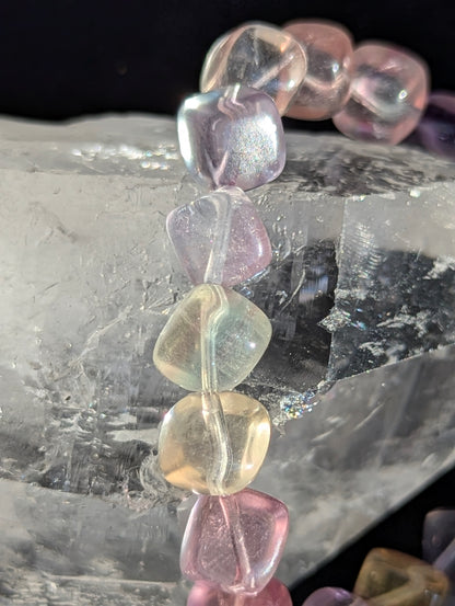 Macro close-up view of polished 9mm Pastel Rainbow Fluorite cubes, highlighting the distinct multi-colour zoning and glass-like polish.