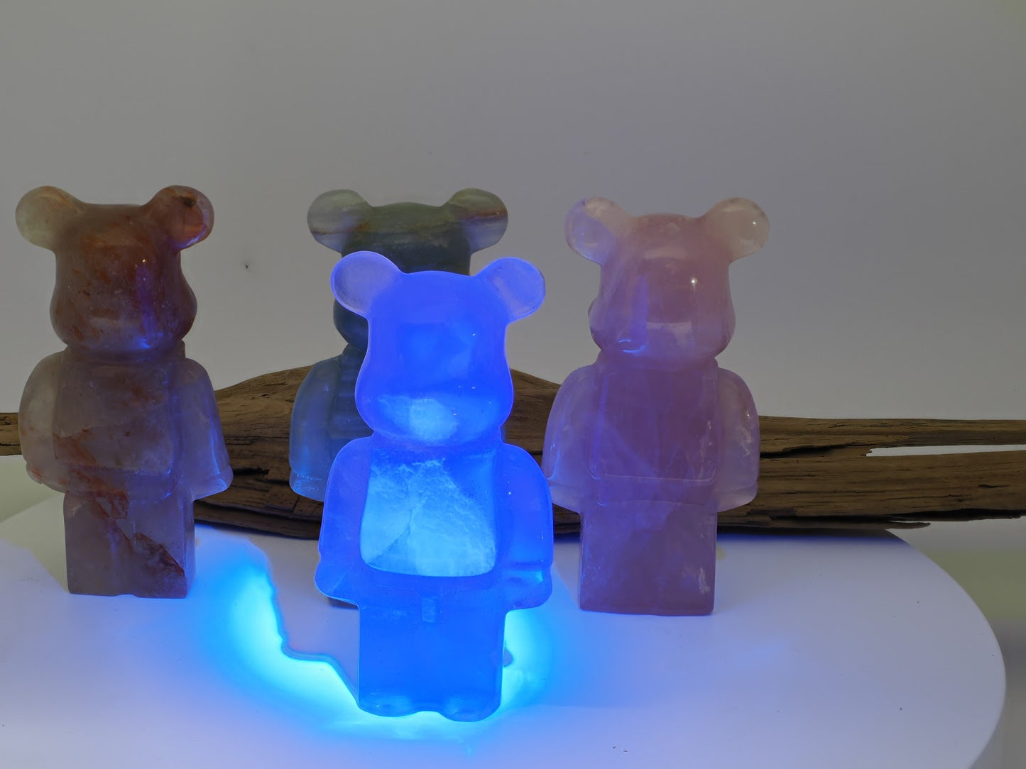 The Fluorite designer bear carving glowing bright neon blue under a 365nm UV light source.