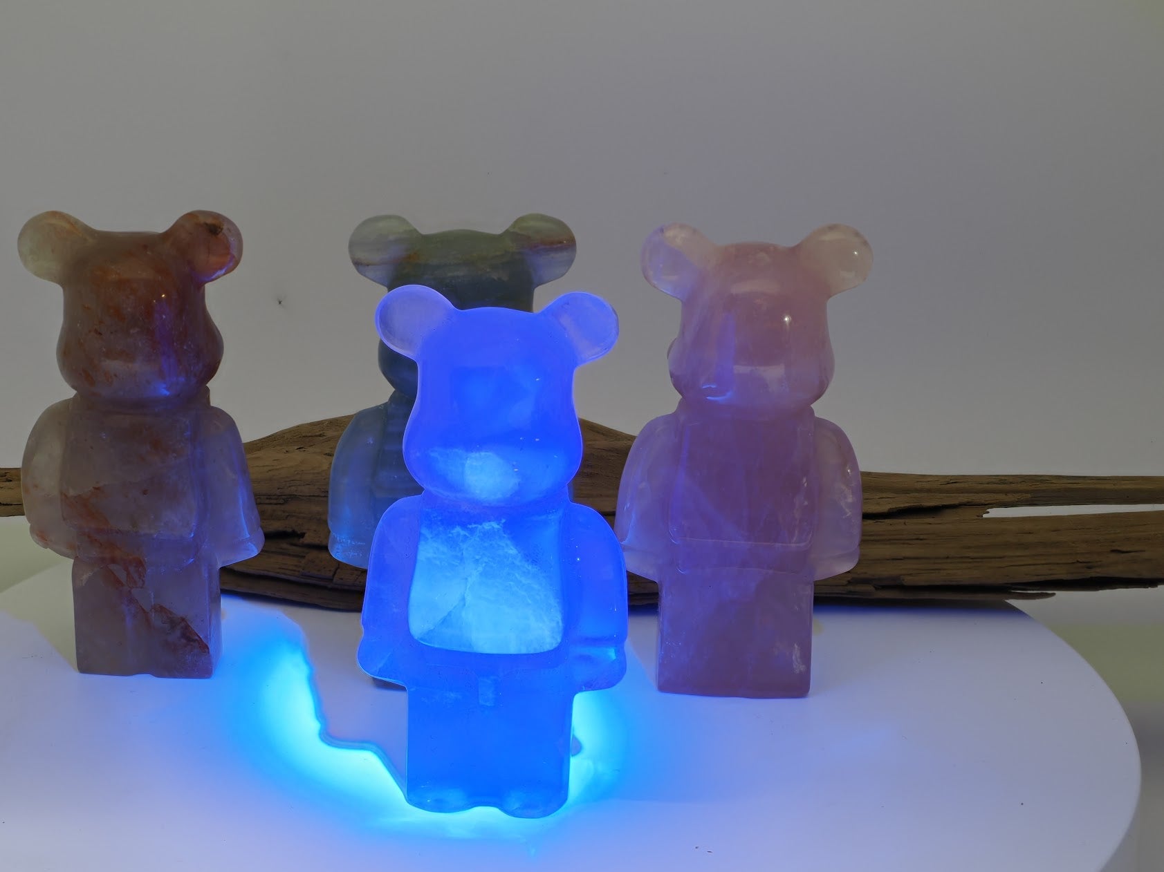 The Fluorite designer bear carving glowing bright neon blue under a 365nm UV light source.