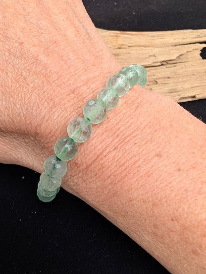 8mm faceted green Fluorite beaded stretch bracelet worn on a wrist for size scale.