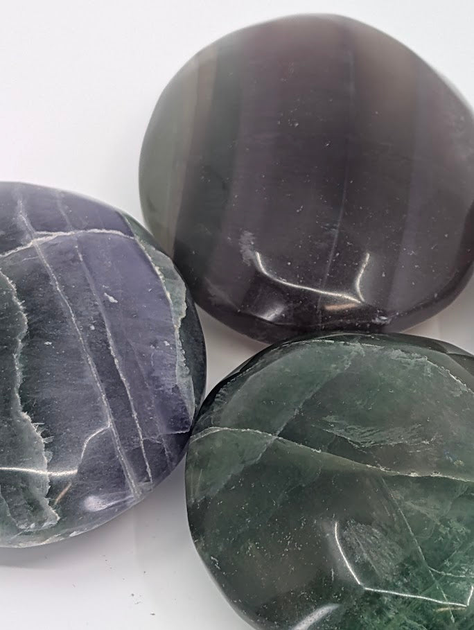 Close-up of polished Fluorite Palm Stones with natural zoning