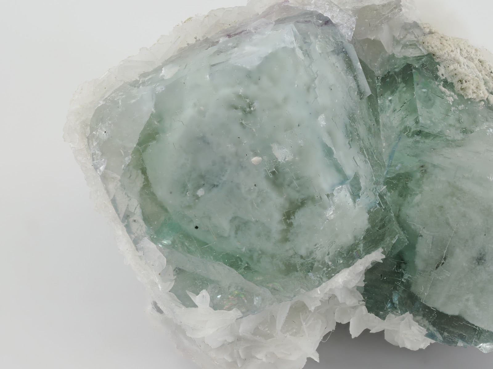 Macro detail of YGX Porcelain Fluorite showing internal green phantom zoning and mottled porcelain-textured crystal faces.