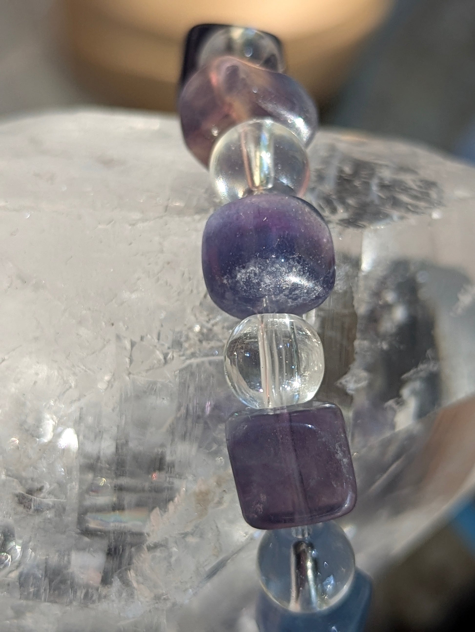 Macro close-up view of polished 9 mm blue fluorite cubes and 8 mm clear quartz spheres, highlighting the vitreous surface luster and exceptional optical clarity of the stones.
