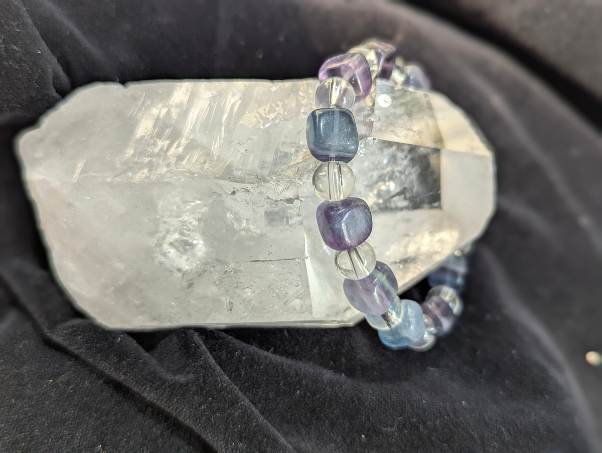Premium blue fluorite and clear quartz beaded stretch bracelet worn on the wrist to demonstrate scale, light refraction, and lapidary uniformity.
