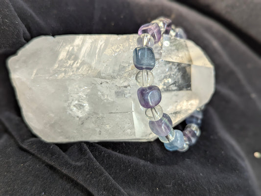 Premium blue fluorite and clear quartz beaded stretch bracelet worn on the wrist to demonstrate scale, light refraction, and lapidary uniformity.