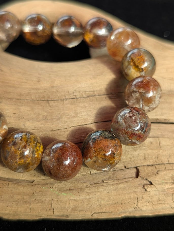 Macro photograph of 13mm Garden Quartz beads highlighting the perfectly clear quartz host material and vivid internal season colours.
