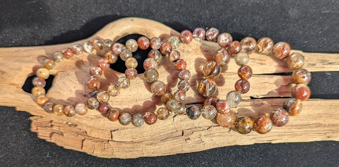 Suite of intuitively selected AA Grade Four Season Garden Quartz beaded stretch bracelets displayed side-by-side on driftwood across sizes 8mm to 13mm.