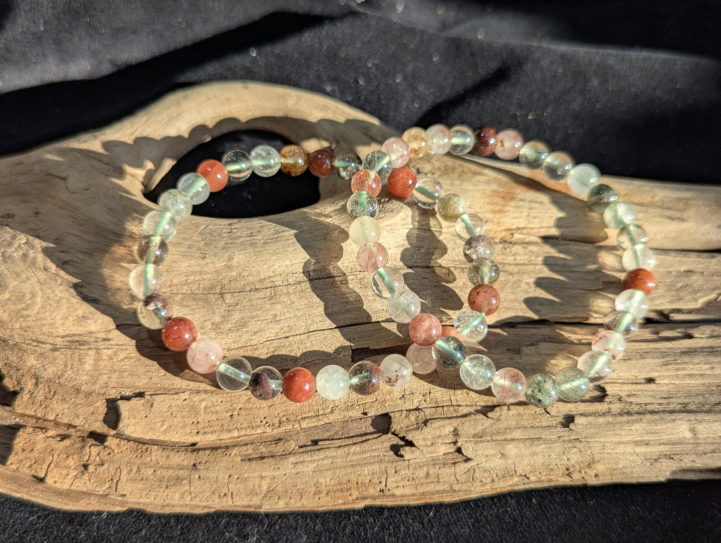An all-natural 6mm Garden Quartz beaded stretch bracelet with rich green chlorite inclusions, displayed on a neutral surface to show bead uniformity.