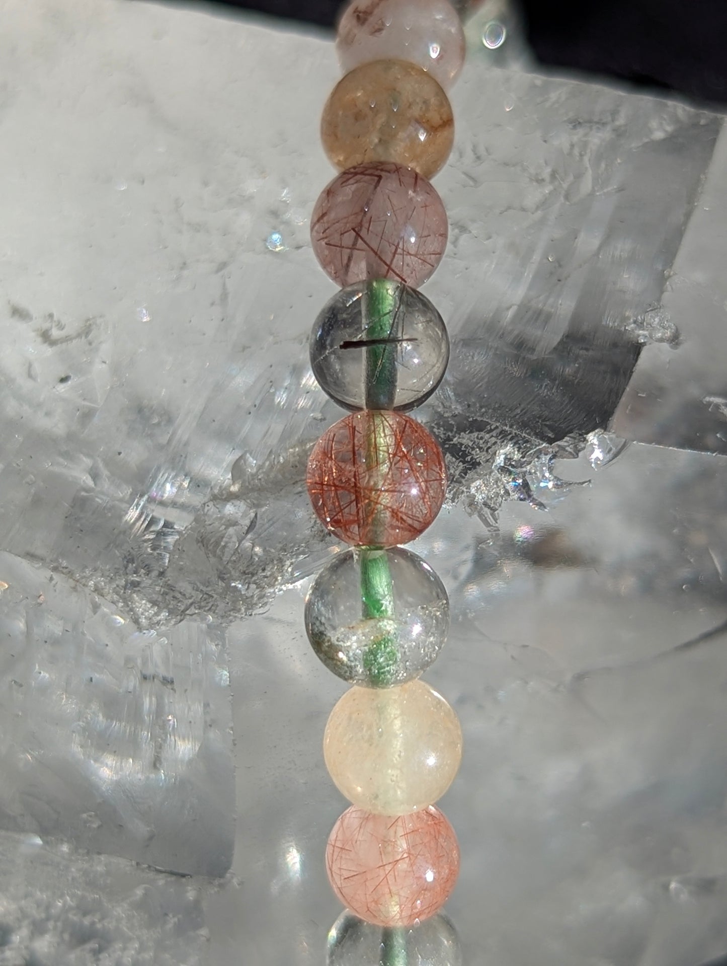 Macro close-up of 6mm Garden Quartz beads, highlighting the clear host quartz and intricate, natural moss-like mineral inclusions inside.