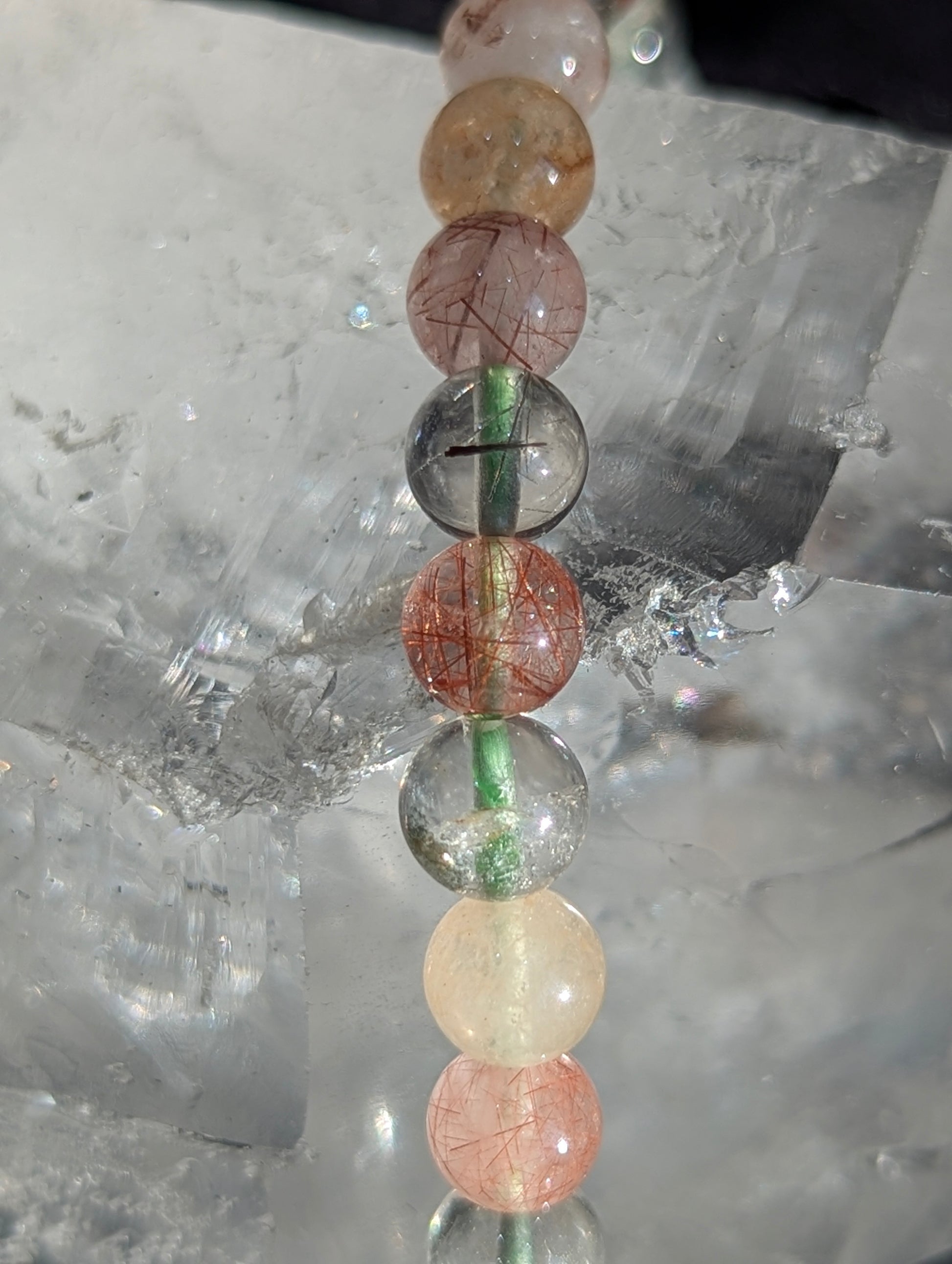 Macro close-up of 6mm Garden Quartz beads, highlighting the clear host quartz and intricate, natural moss-like mineral inclusions inside.