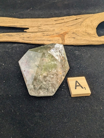 Angled view of exact piece Garden Quartz faceted freeform, Variant A1, highlighting the layered inclusions.