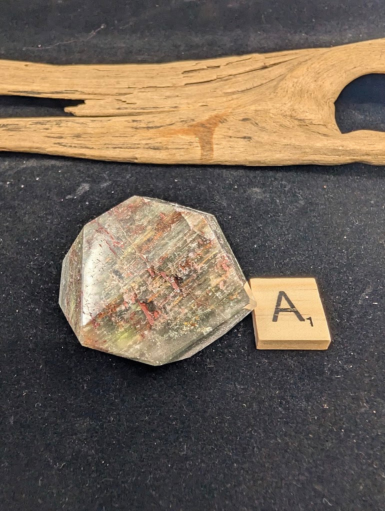 Exact piece Garden Quartz faceted freeform, Variant A1, showcasing dense, striated red iron oxide and green chlorite inclusions.