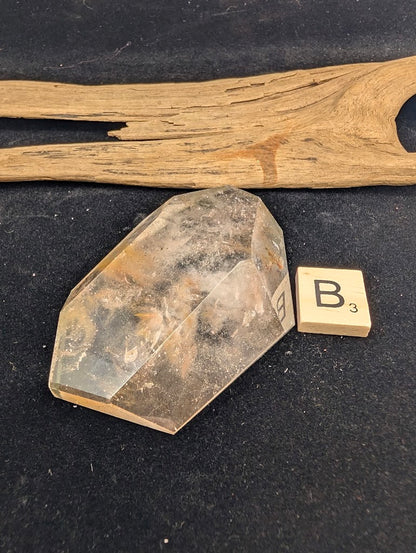 Exact piece Garden Quartz faceted freeform, Variant B3, featuring a concentrated internal landscape with yellow limonite staining and dark minerals.