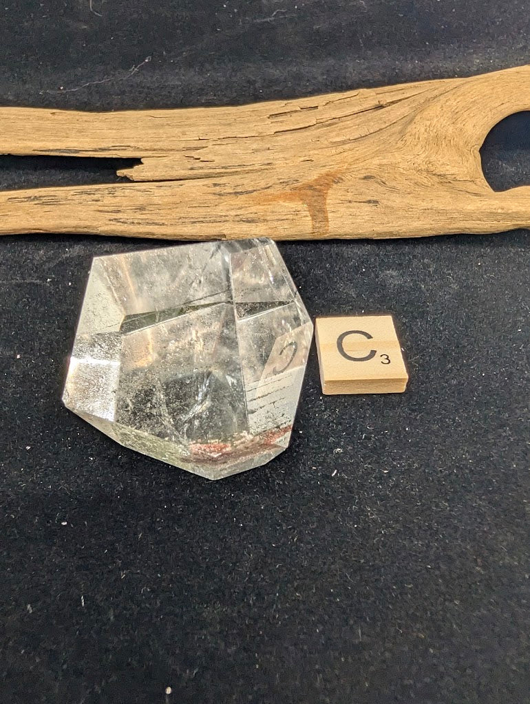 Angled view of exact piece Garden Quartz faceted freeform, Variant C3, highlighting the clear optical window.