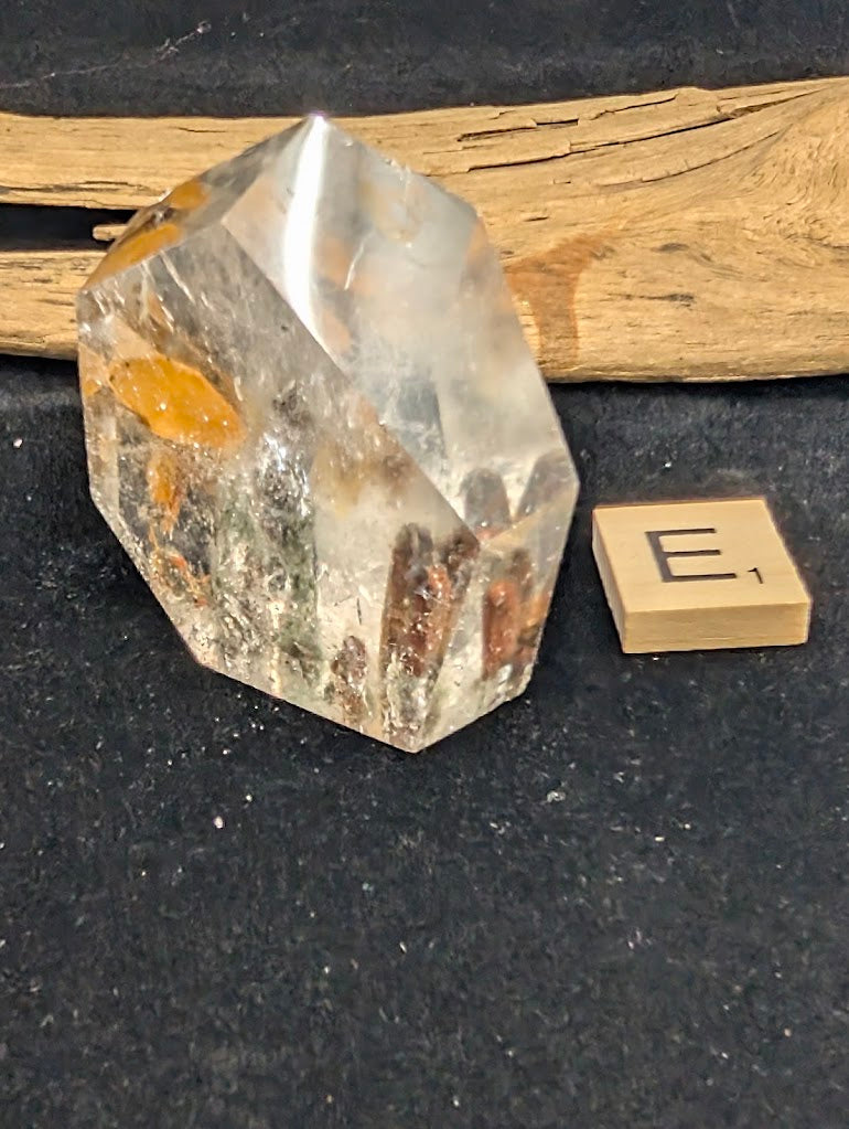 Angled view of exact piece Garden Quartz faceted freeform, Variant E1, showing yellow staining alongside tubular inclusions.